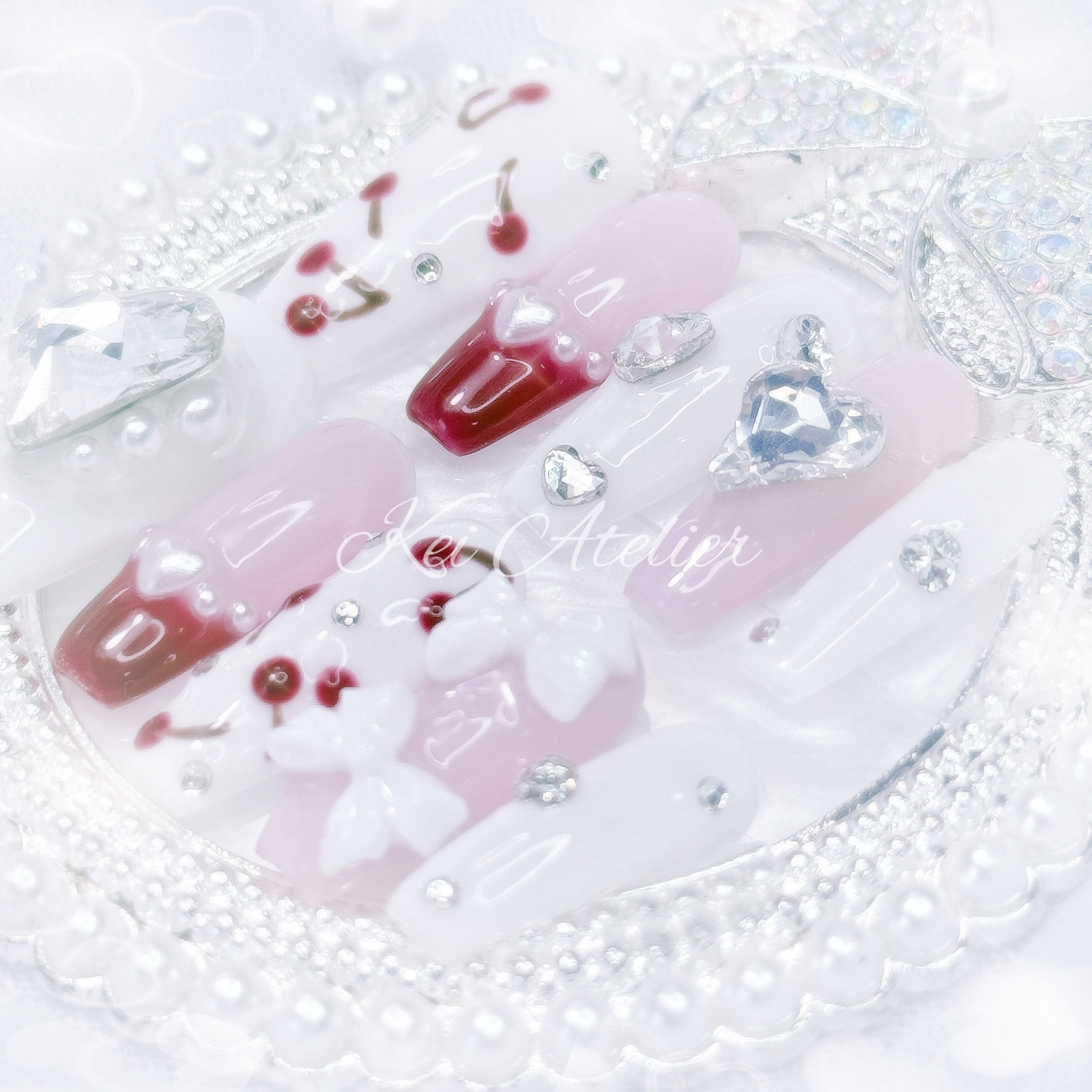 kawaii japanese ryousangata jirai gyaru style handmade press-on nail set featuring pink, white, and cherry red jelly gels, bejeweled in heart crystal rhinestone charms, white bows, pearls, and hand-painted cherries, perfect for summer, bold yet soft