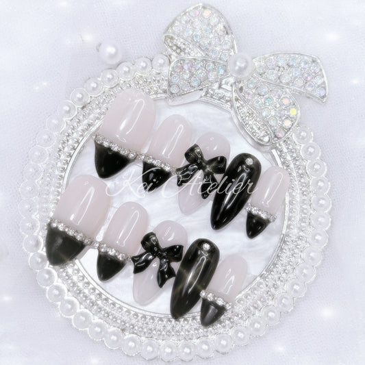kawaii elegant chic coquette ryousangata jirai goth style handmade press-on nail set featuring nude and black gels, straight-across black french tips, rhinestones, and black bows
