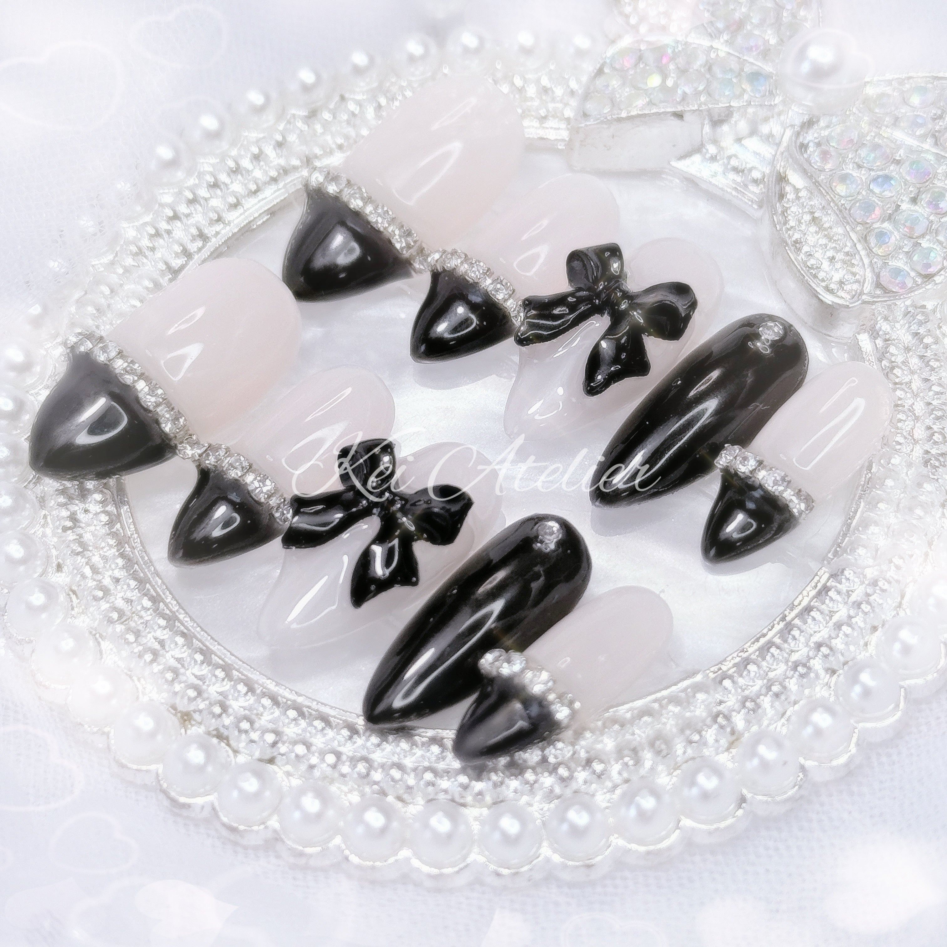 kawaii elegant chic coquette ryousangata jirai goth style handmade press-on nail set featuring nude and black gels, straight-across black french tips, rhinestones, and black bows