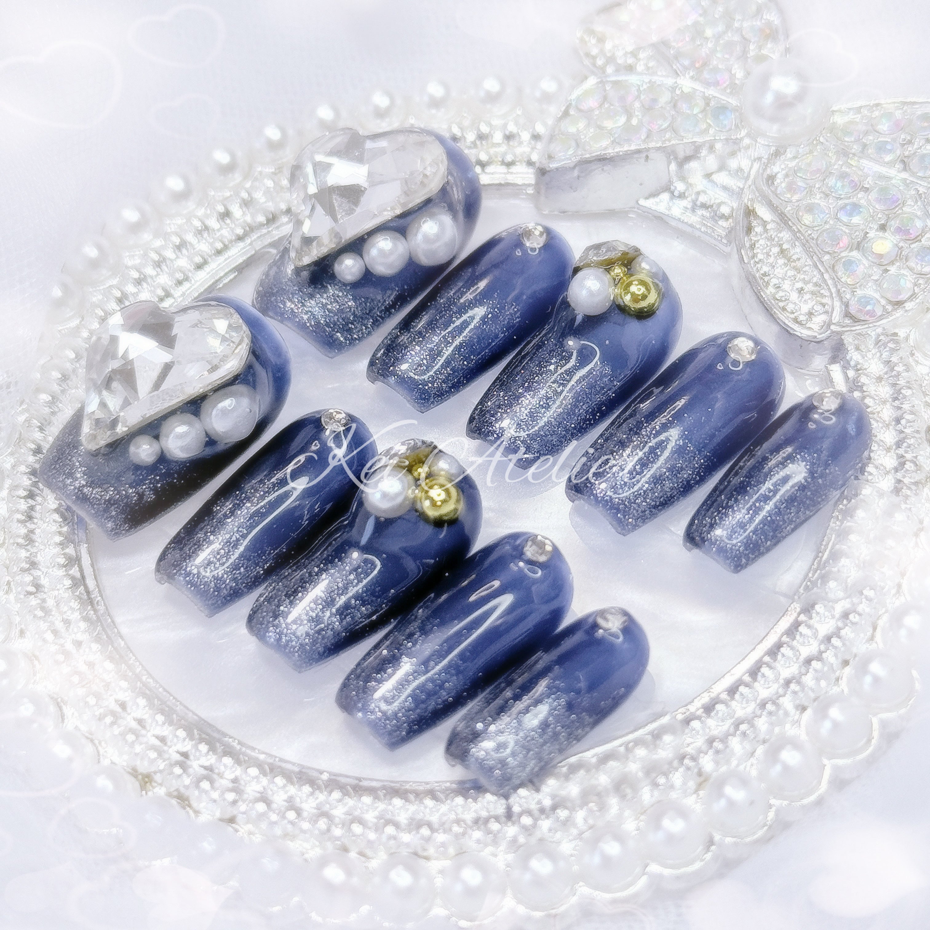 kawaii elegant japanese ryousangata jirai style handmade press-on nail set featuring dark blue and shimmery glitter gels, decorated with pearls, gold caviar beads, rhinestones, jewels, and a big white heart jewel