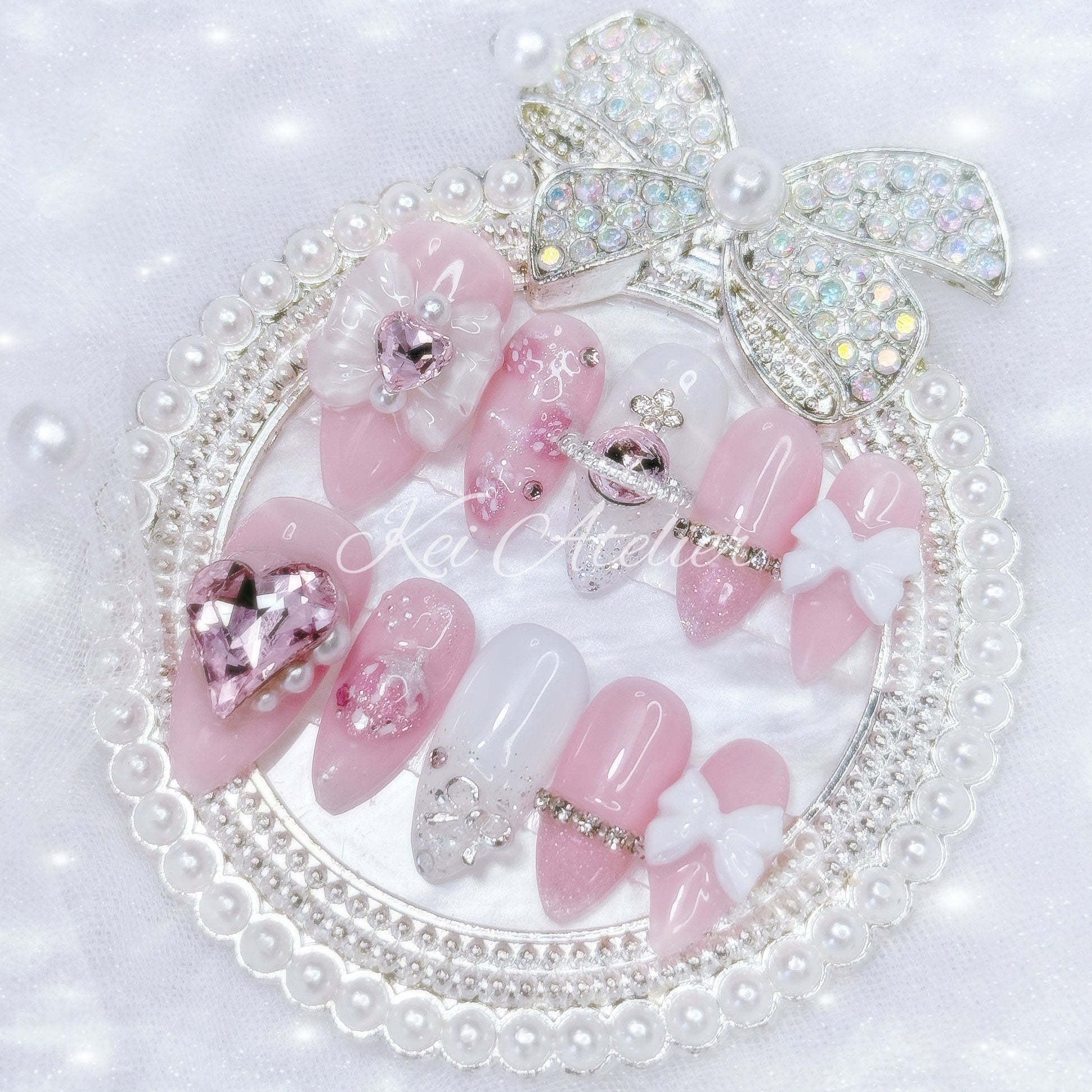 Japanese style handmade press-on nail set featuring pink and white gels, 3d strawberry design, glitter, pearls, rhinestones, ribbon and bow charms, inspired by the Nana series