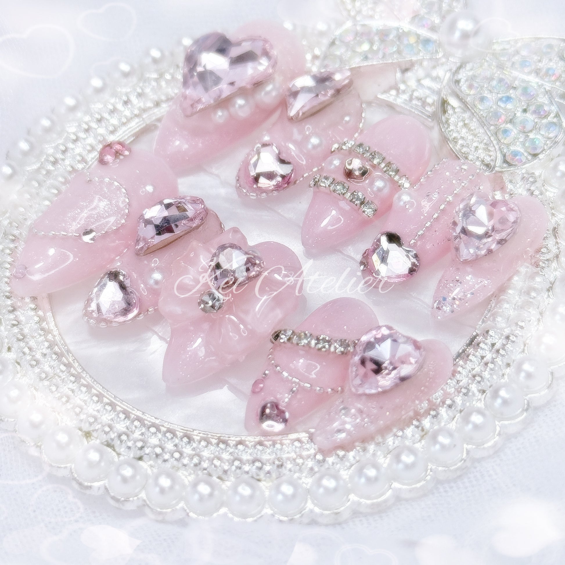 Kawaii Japanese ryousangata jirai style handmade press-on nail set featuring pink sparkly gel, bejeweled in heart crystal rhinestones, pearls, and glitter.