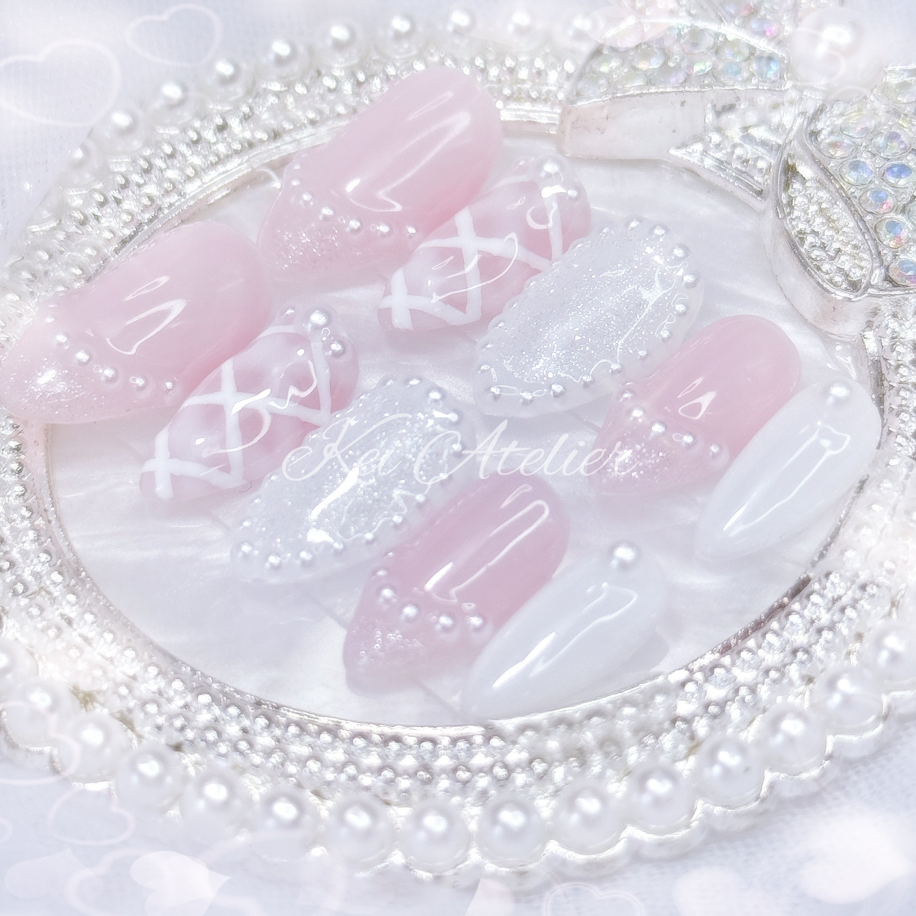 kawaii japanese ryousangata jirai coquette style handmade press-on nail set featuring pink and white gels, a lattice pattern, and pearls lining the french tips and boarders
