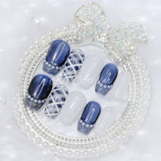 kawaii japanese ryousangata jirai coquette style handmade press-on nail set featuring royal blue and white gels, a lattice pattern, and pearls lining the french tips and boarders