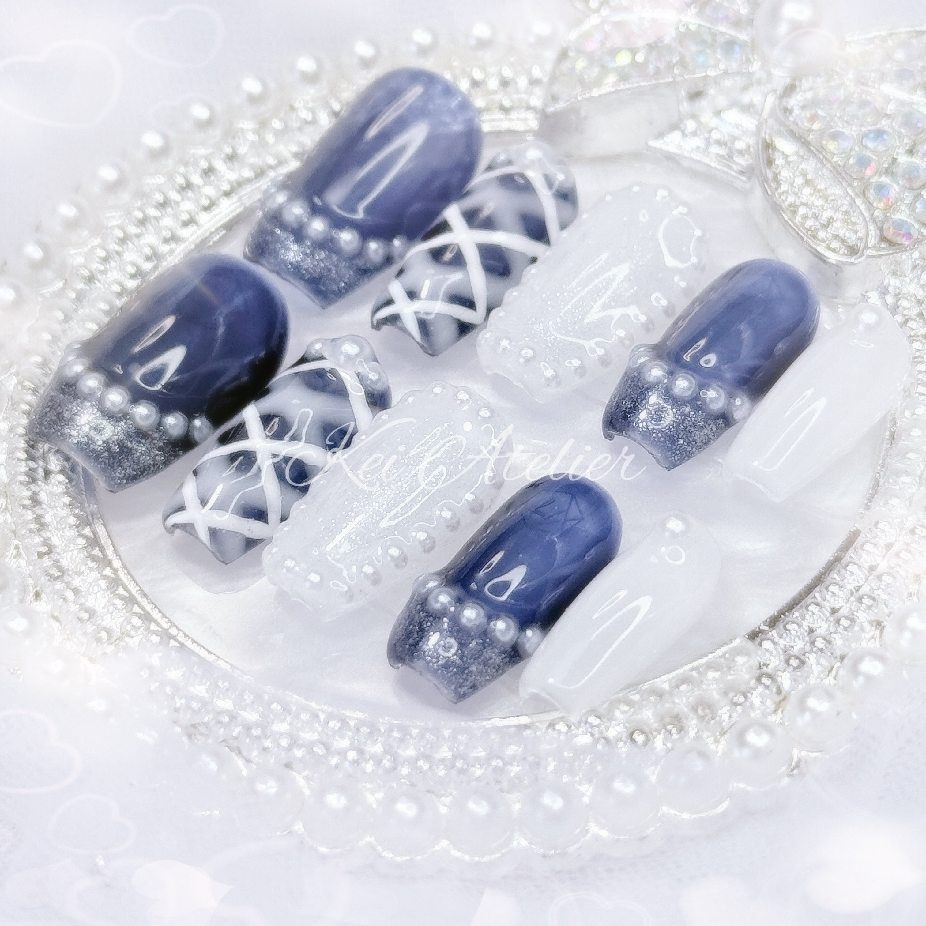 kawaii japanese ryousangata jirai coquette style handmade press-on nail set featuring royal blue and white gels, a lattice pattern, and pearls lining the french tips and boarders