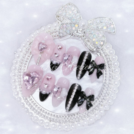 Kawaii Japanese ryousangata jirai style handmade press-on nail set featuring pink and black gels, glitter, pearls, heart bijoux, rhinestones, bows and ribbons