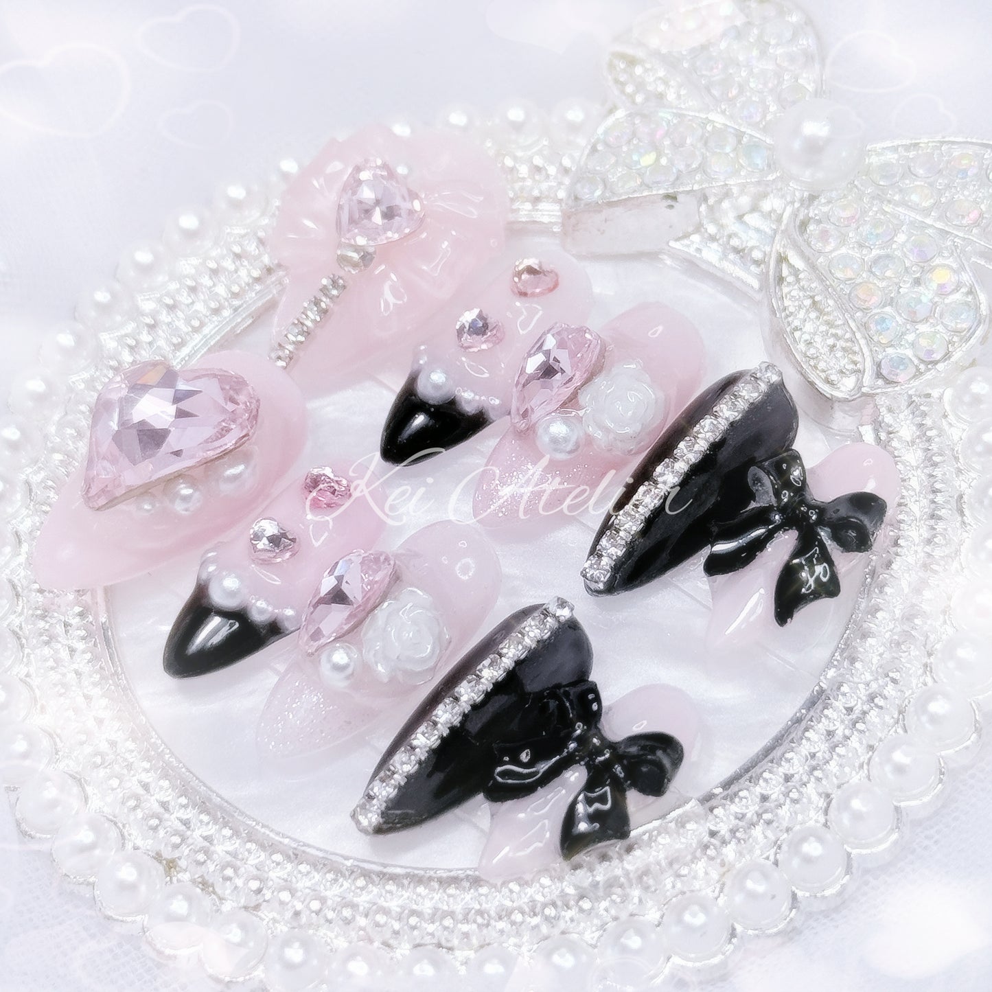 Kawaii Japanese ryousangata jirai style handmade press-on nail set featuring pink and black gels, glitter, pearls, heart bijoux, rhinestones, bows and ribbons