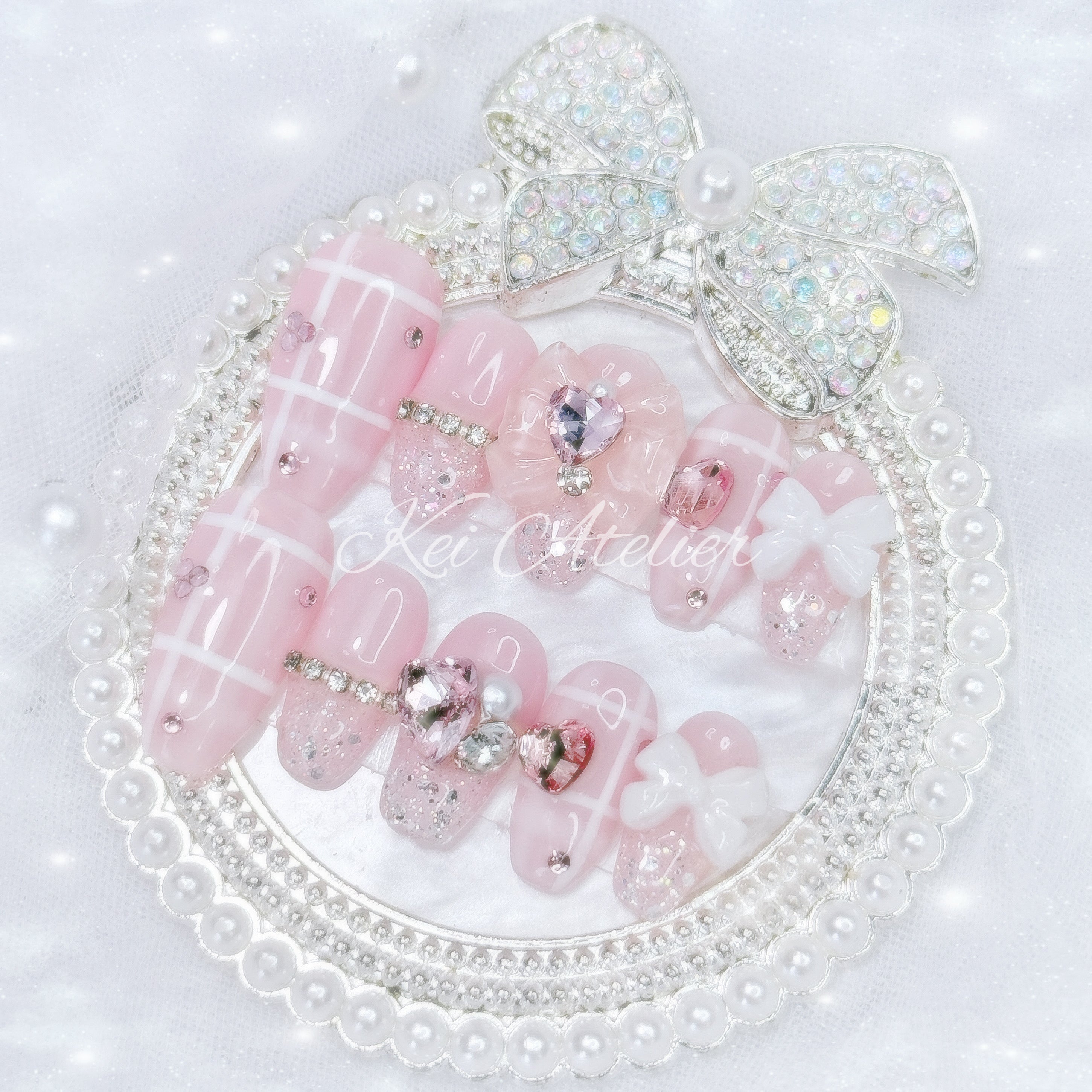Kawaii Japanese ryousangata jirai style handmade press-on nail set featuring a pink and white plaid design, with pink heart crystals, ribbons, bows, and sparkly silver glitter