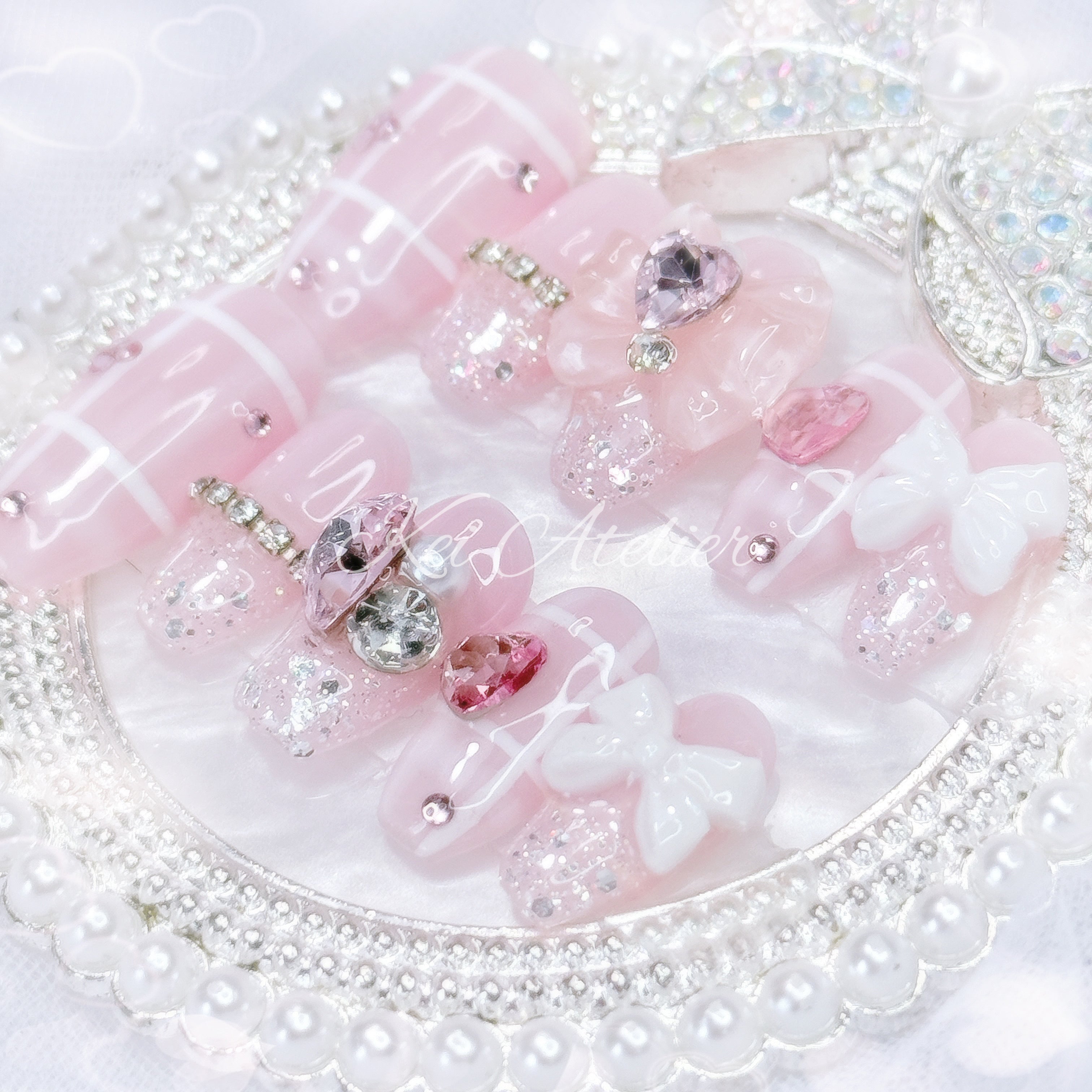 Kawaii Japanese ryousangata jirai style handmade press-on nail set featuring a pink and white plaid design, with pink heart crystals, ribbons, bows, and sparkly silver glitter