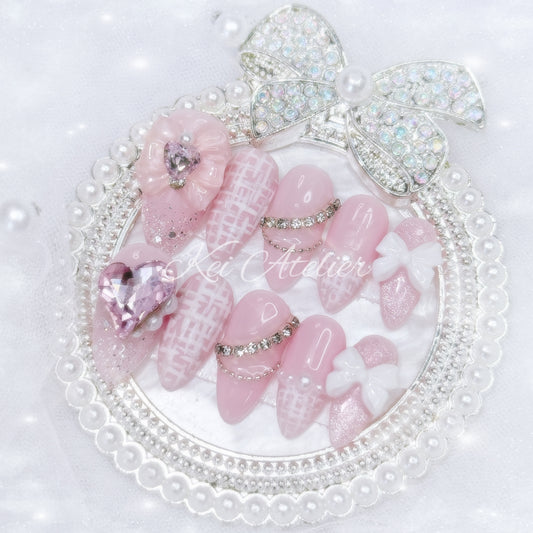 Kawaii Japanese ryousangata jirai style handmade press-on nail set featuring a pink and white tweed design, matte tweed french tip, cat eye, bejeweled with ribbons, bows, hearts, pearls