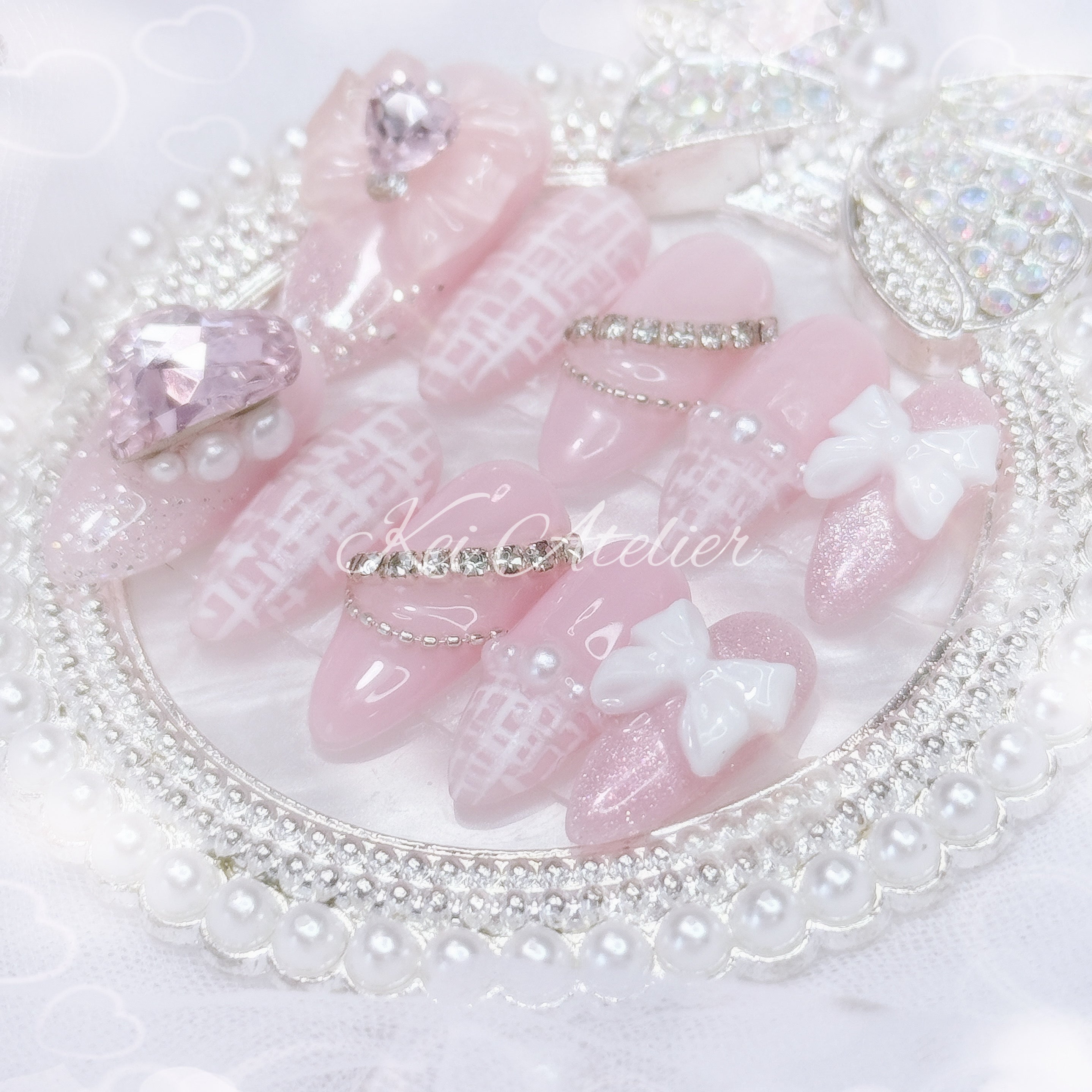 Kawaii Japanese ryousangata jirai style handmade press-on nail set featuring a pink and white tweed design, matte tweed french tip, cat eye, bejeweled with ribbons, bows, hearts, pearls