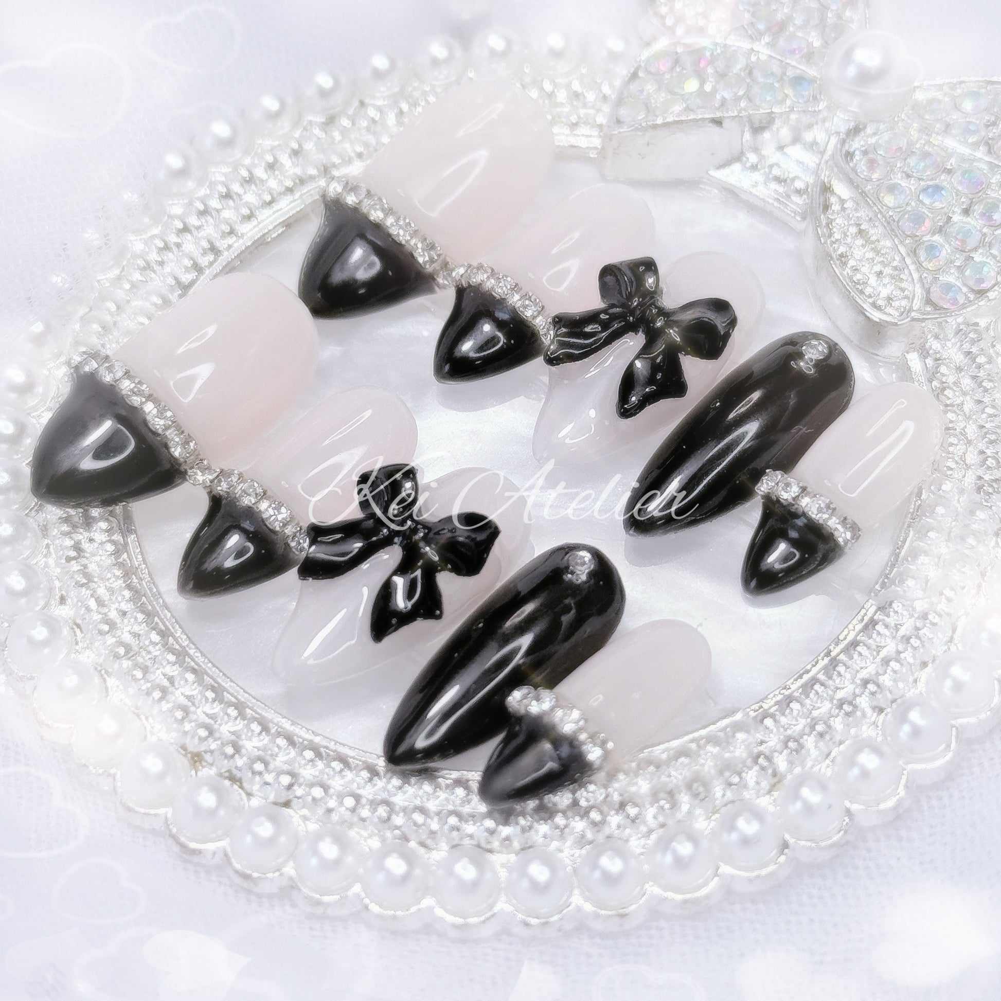 kawaii elegant chic coquette ryousangata jirai goth style handmade press-on nail set featuring nude and black gels, straight-across black french tips, rhinestones, and black bows