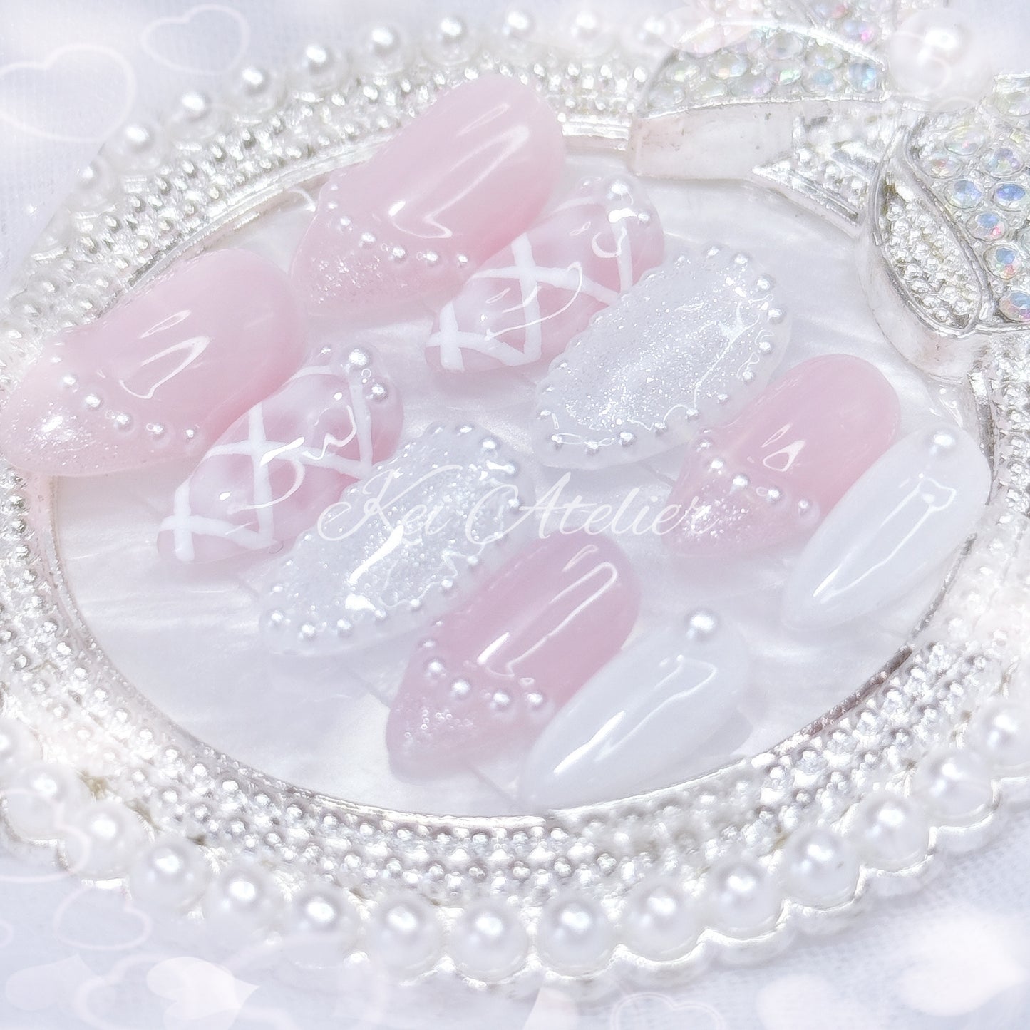 kawaii japanese ryousangata jirai coquette style handmade press-on nail set featuring pink and white gels, a lattice pattern, and pearls lining the french tips and boarders