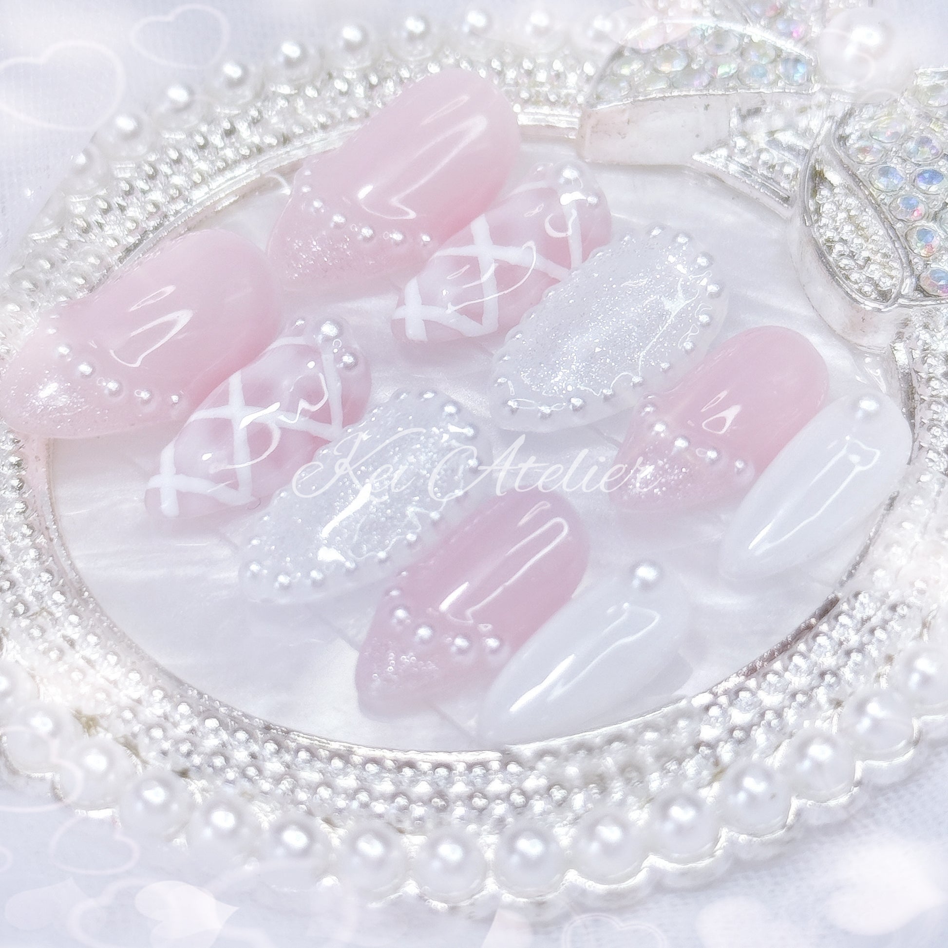 kawaii japanese ryousangata jirai coquette style handmade press-on nail set featuring pink and white gels, a lattice pattern, and pearls lining the french tips and boarders