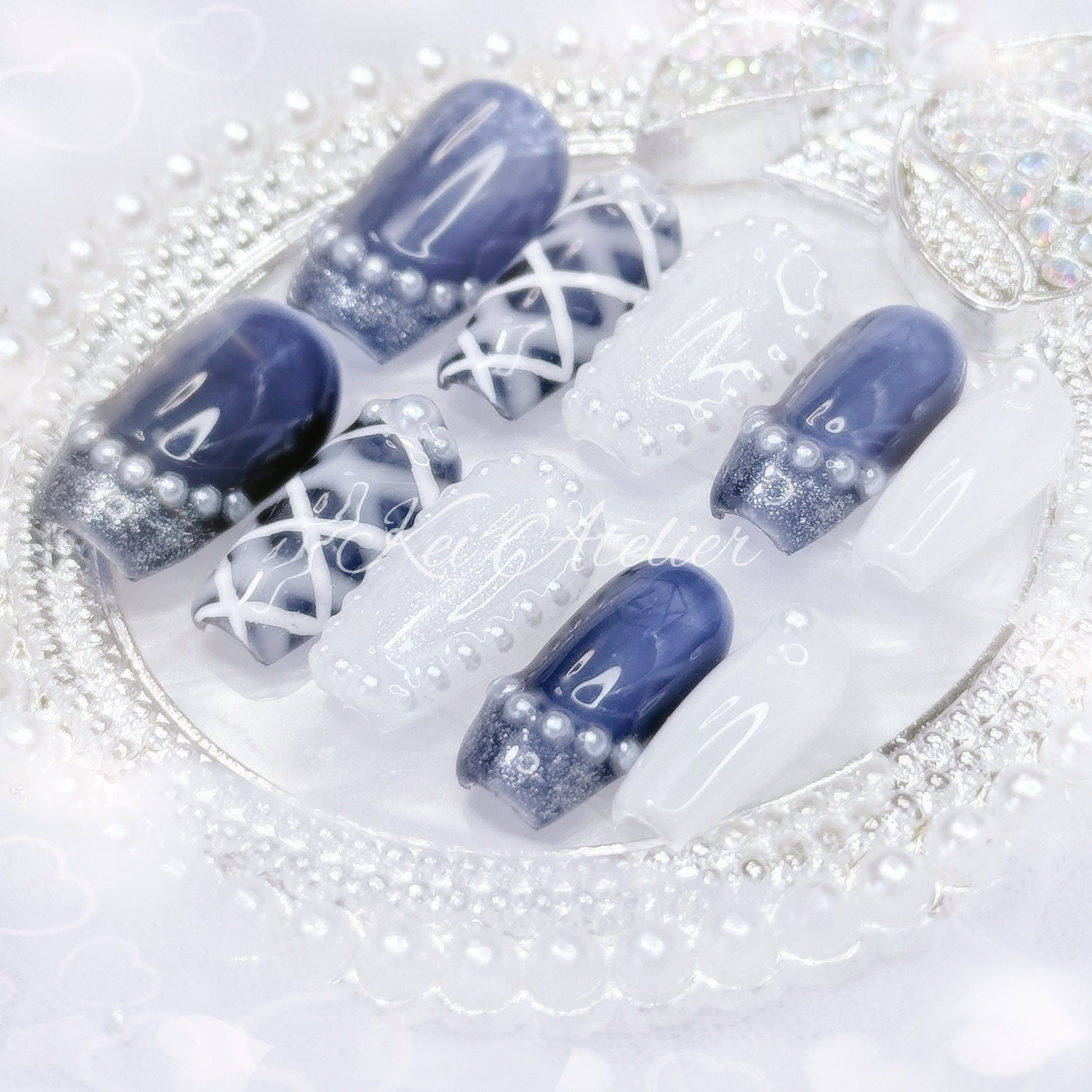 kawaii japanese ryousangata jirai coquette style handmade press-on nail set featuring royal blue and white gels, a lattice pattern, and pearls lining the french tips and boarders